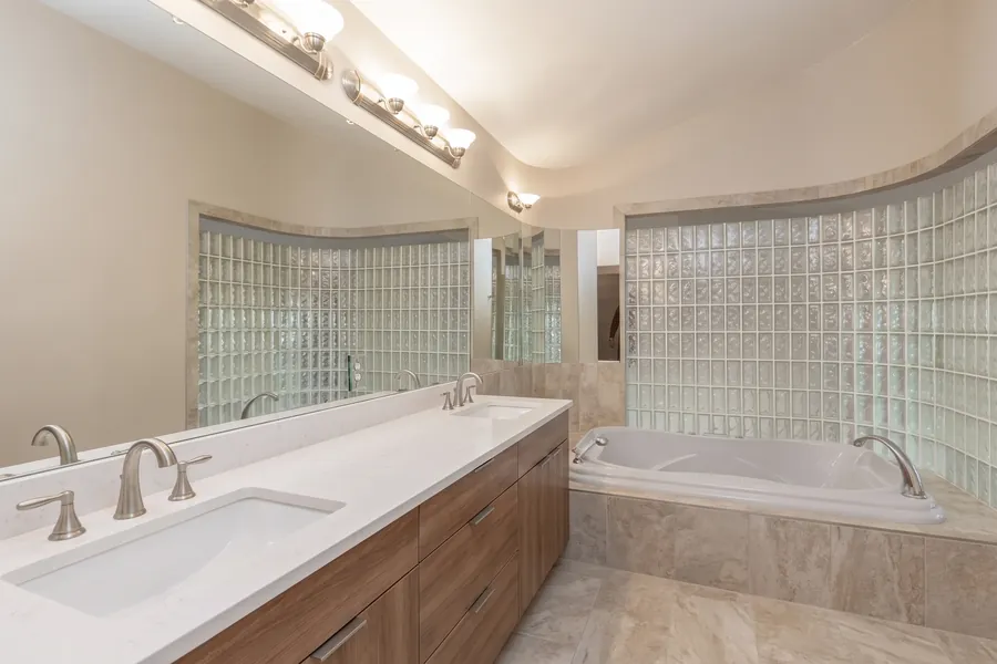 AI design concept of the same bathroom: wood-look vanity, white quartz top and stone-look porcelain on the tub surround and floor