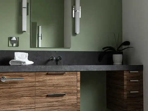 Bathroom with a sage wall and walnut floating vanity
