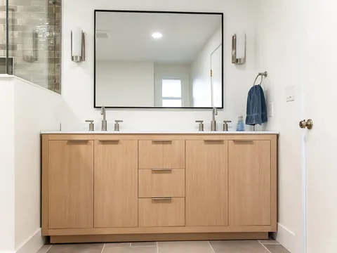 Bathroom with a white oak double vanity and black framed mirror
