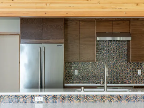 Walnut kitchen with a glass mosaic backsplash