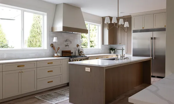 Kitchen with greige cabinets, a wood island and a large range hood, remodeled by JDI Construction