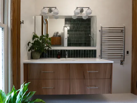 Bathroom with a walnut floating vanity and green tile
