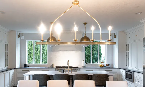 White kitchen with a brass chandelier, remodeled by JDI Construction